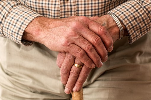 Senior citizen hands on cane